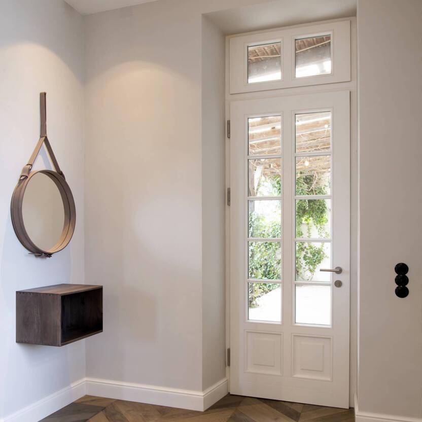 Eingangsbereich mit weißer Tür aus Glas und Holz