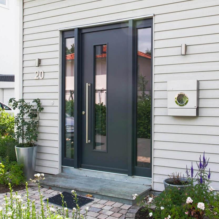 Eingangstür in Anthrazit mit schmalem vertikalem Fenster