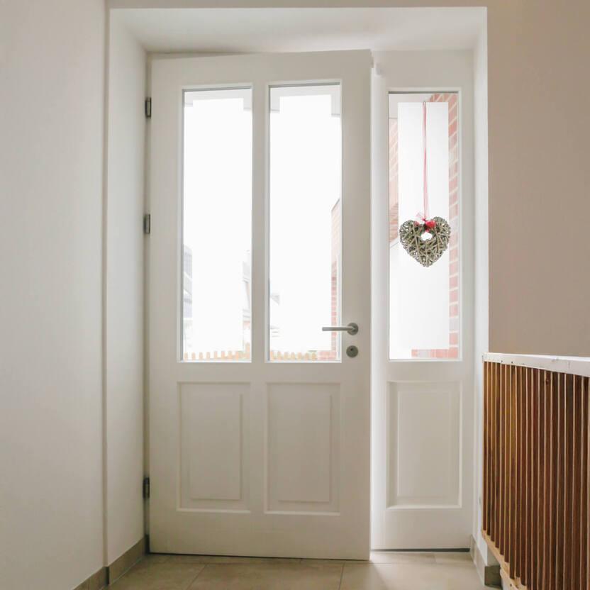 Weiße Haustür mit zwei vertikalen Fenstern und einem schmalen Seitenfenster