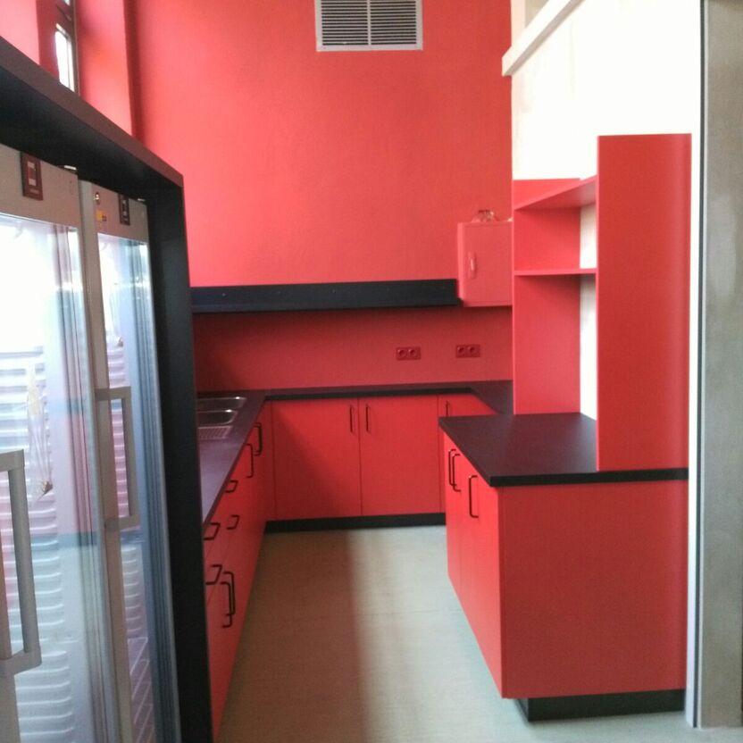 Stilvolle maßgefertigte Küche in Rot Eine auffällige Küche in intensivem Rot mit maßgefertigten Schränken und einer modernen Kücheninsel, die Funktionalität und Design verbindet. Ideal für Küchen nach Maß.