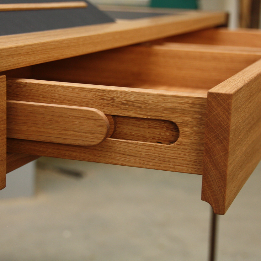 Nahaufnahme einer handgefertigten Holzschublade, die Präzision und handwerkliches Geschick im Möbelbau zeigt, mit sichtbarer Holzmaserung und passgenauen Fugen.