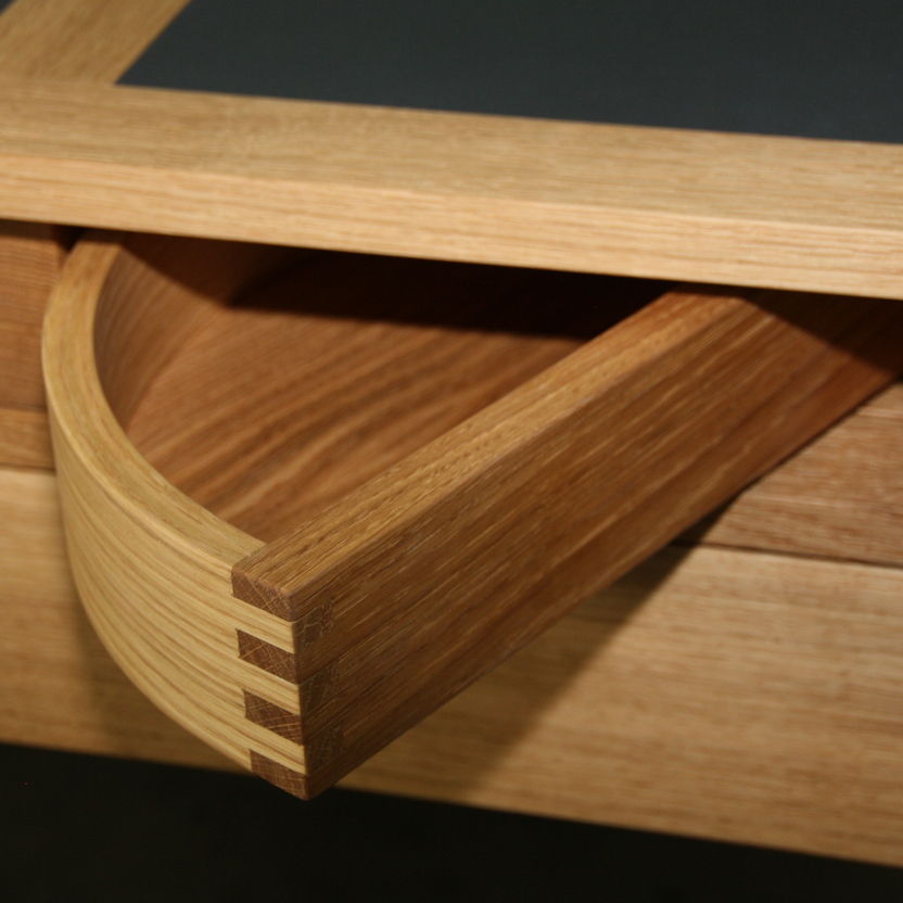 Detailaufnahme einer eleganten, runden Schublade aus Holz, meisterhaft gefertigt, zeigt die Präzision und Kreativität im Möbelbau.