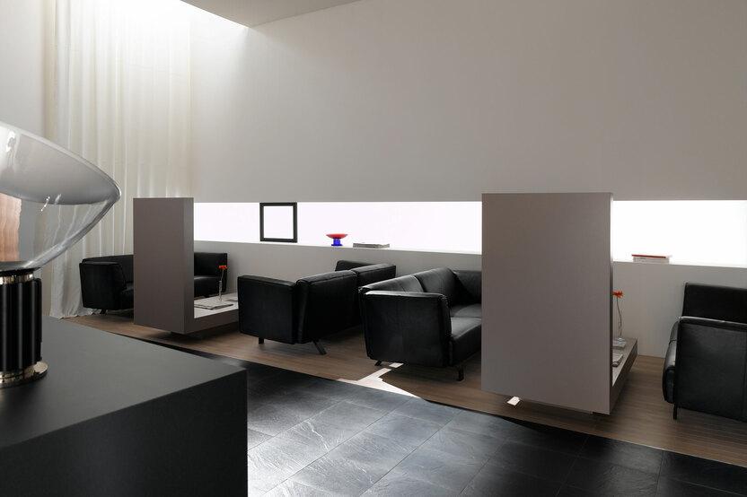 Hotellobby mit Trennwänden aus Holz Hotellobby mit Trennwänden aus Holz und schwarzen Ledersofas