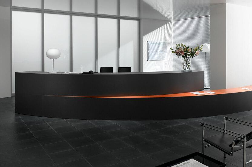 Hotelrezeption mit schwarzem Einrichtungsstil Hotelrezeption mit schwarz lackierter Empfangstheke und orangenem Kontrast