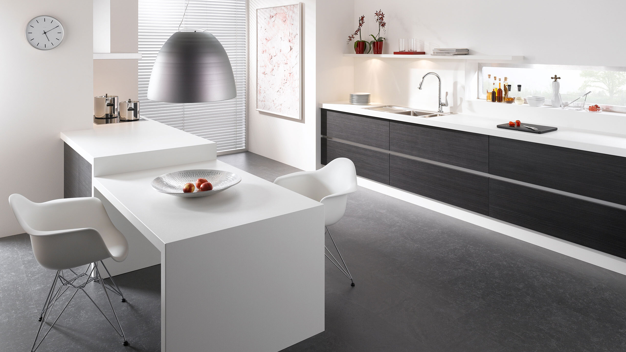 Impression einer einzeiligen K&uuml;chengestaltung in schwarz-wei&szlig; mit Esstisch f&uuml;r Zwei