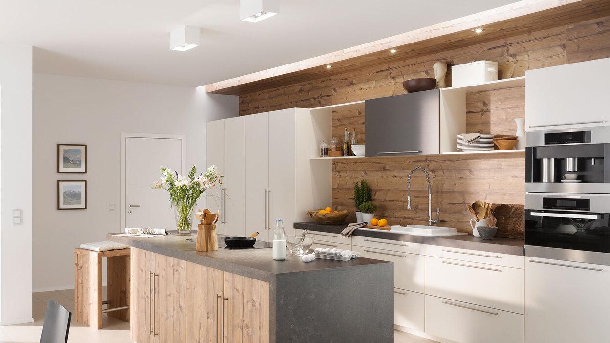 Impressionen einer K&uuml;che mit Esszimmer mit hellen Holzm&ouml;beln und dunklen und wei&szlig;en Fronten im Kontrast