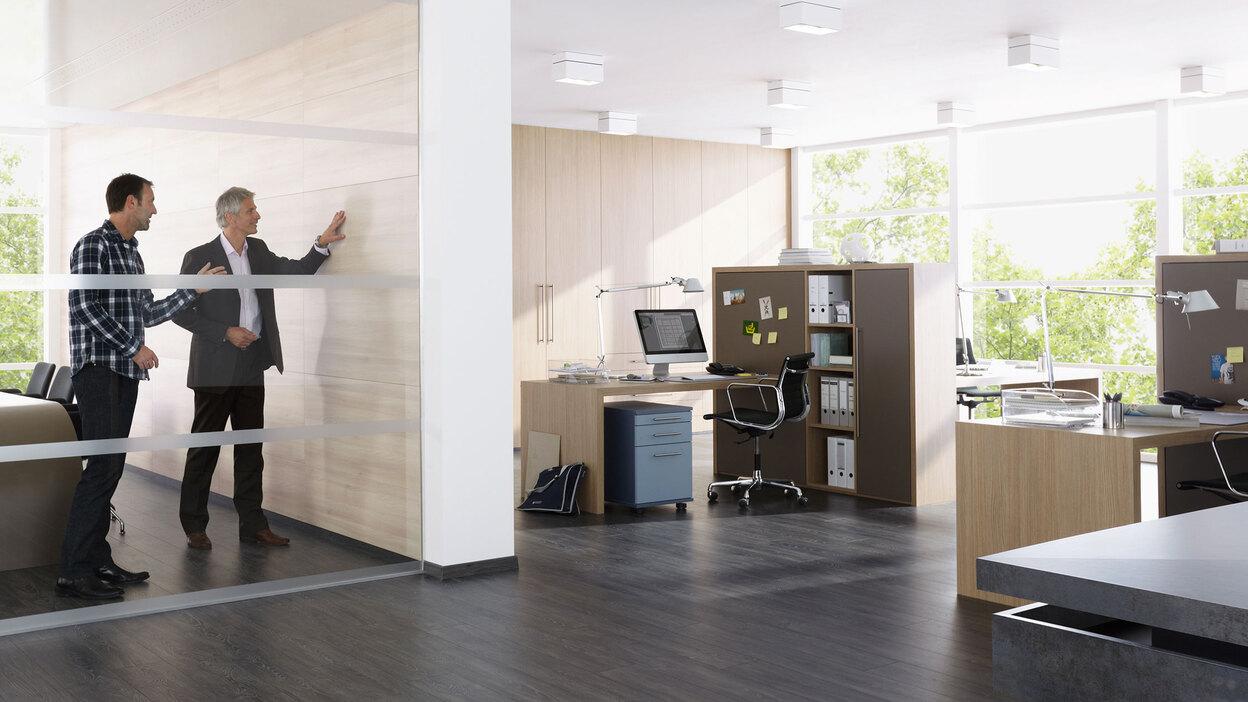 Impression eines Büros mit abgeschlossenem Raum. Impression eines Büros mit abgeschlossenem Raum mit Glaswand und offener Bürogestaltung.
