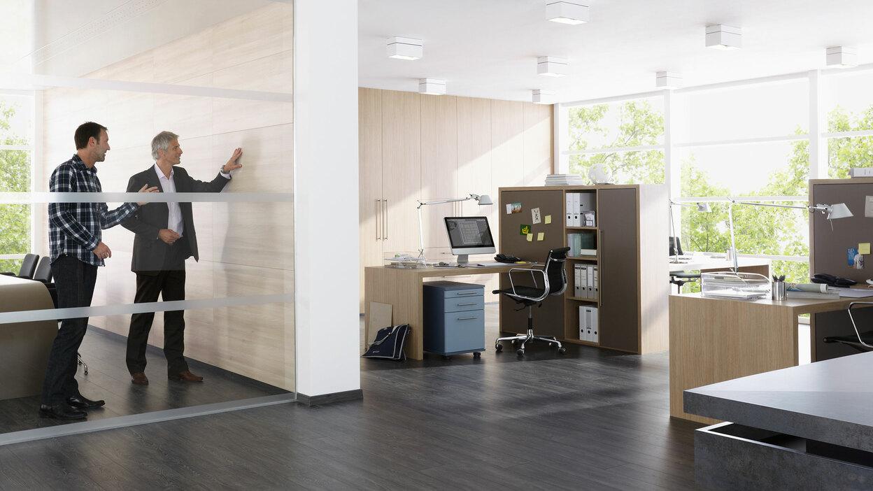 Impression eines Büros mit abgeschlossenem Raum. Impression eines Büros mit abgeschlossenem Raum mit Glaswand und offener Bürogestaltung.